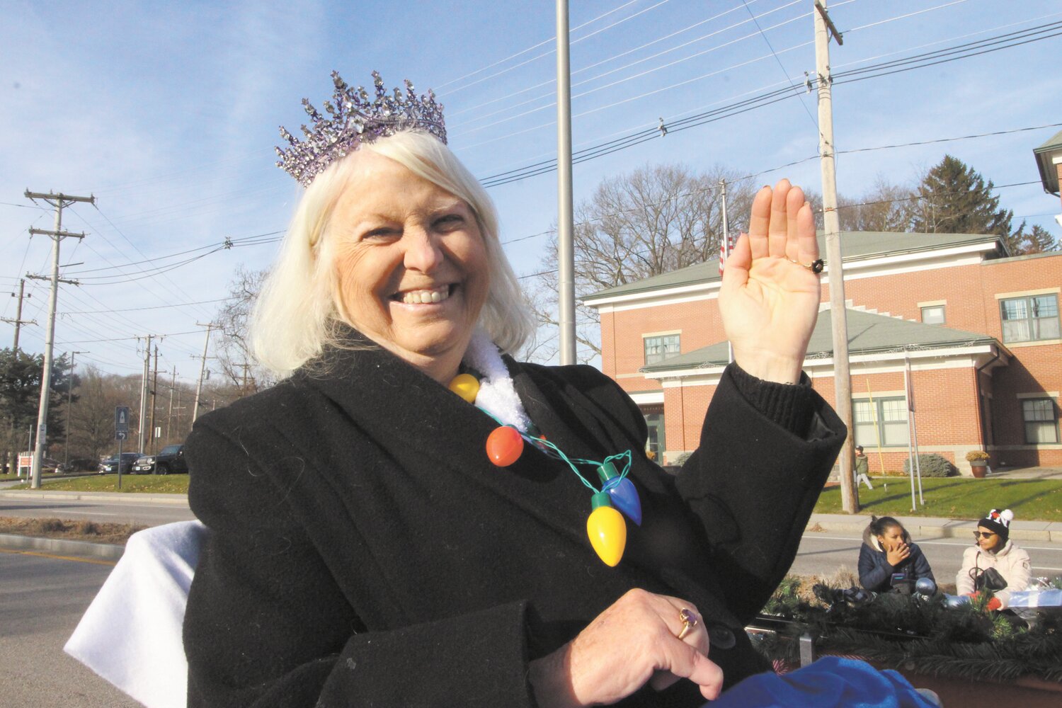 PARADE MARSHAL: Pegee Malcolm practices her wave before leading the first-ever Apponaug Winter Fest parade as grand marshal. On Monday the City Council reappointed her to the Warwick Historical Cemeteries Commission that she chairs. (Warwick Beacon photo)